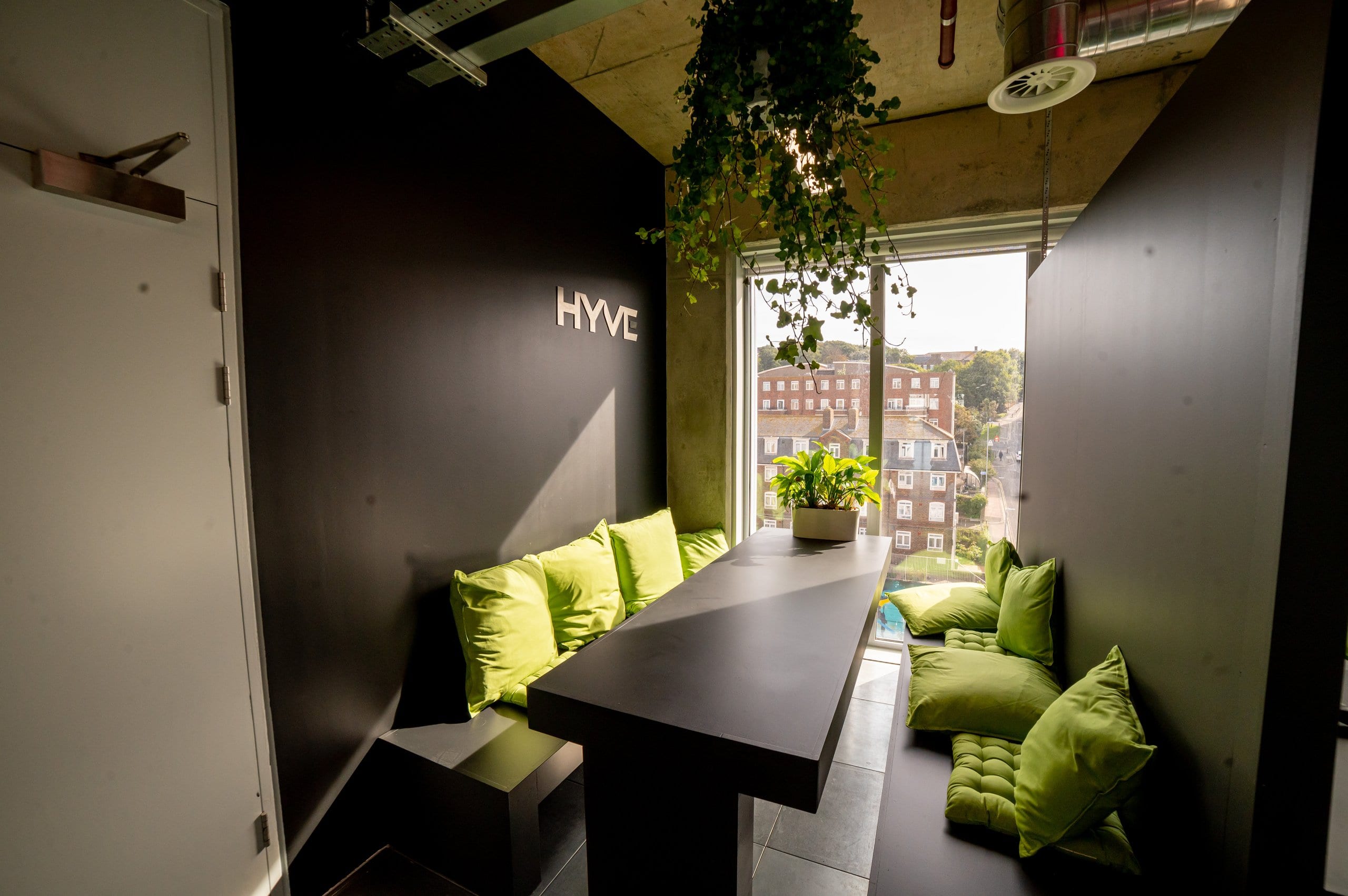 Hyve lounge with green cushions