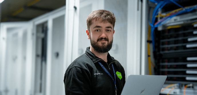 Hyve engineer smiling in a server room
