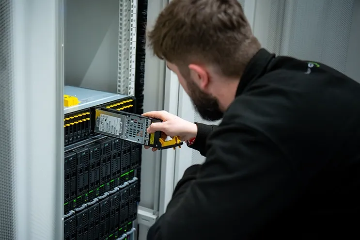 Engineer installing a drive in a server rack