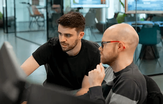 Two colleagues reviewing a screen in an office