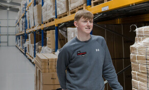 Young man walking through a warehouse, Work Place Depot Logo